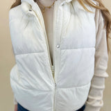 Women’s white hooded puffer vest with hidden zipper and snap closure from Shear Boutique.