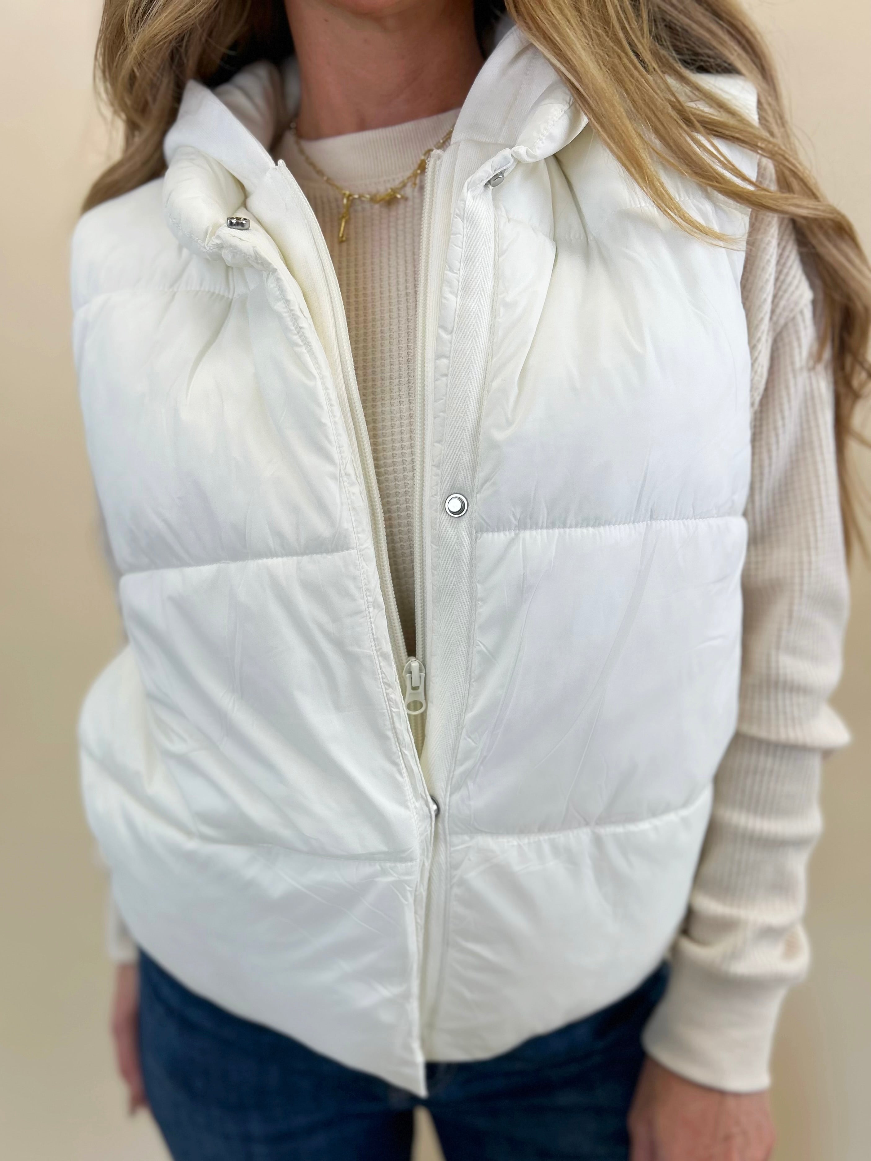 Women’s white hooded puffer vest with hidden zipper and snap closure from Shear Boutique.
