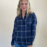 Soft-washed Z Supply River Plaid Button-Up in blue and white, featuring a collared neckline, button-front closure, long sleeves, and a single chest pocket.