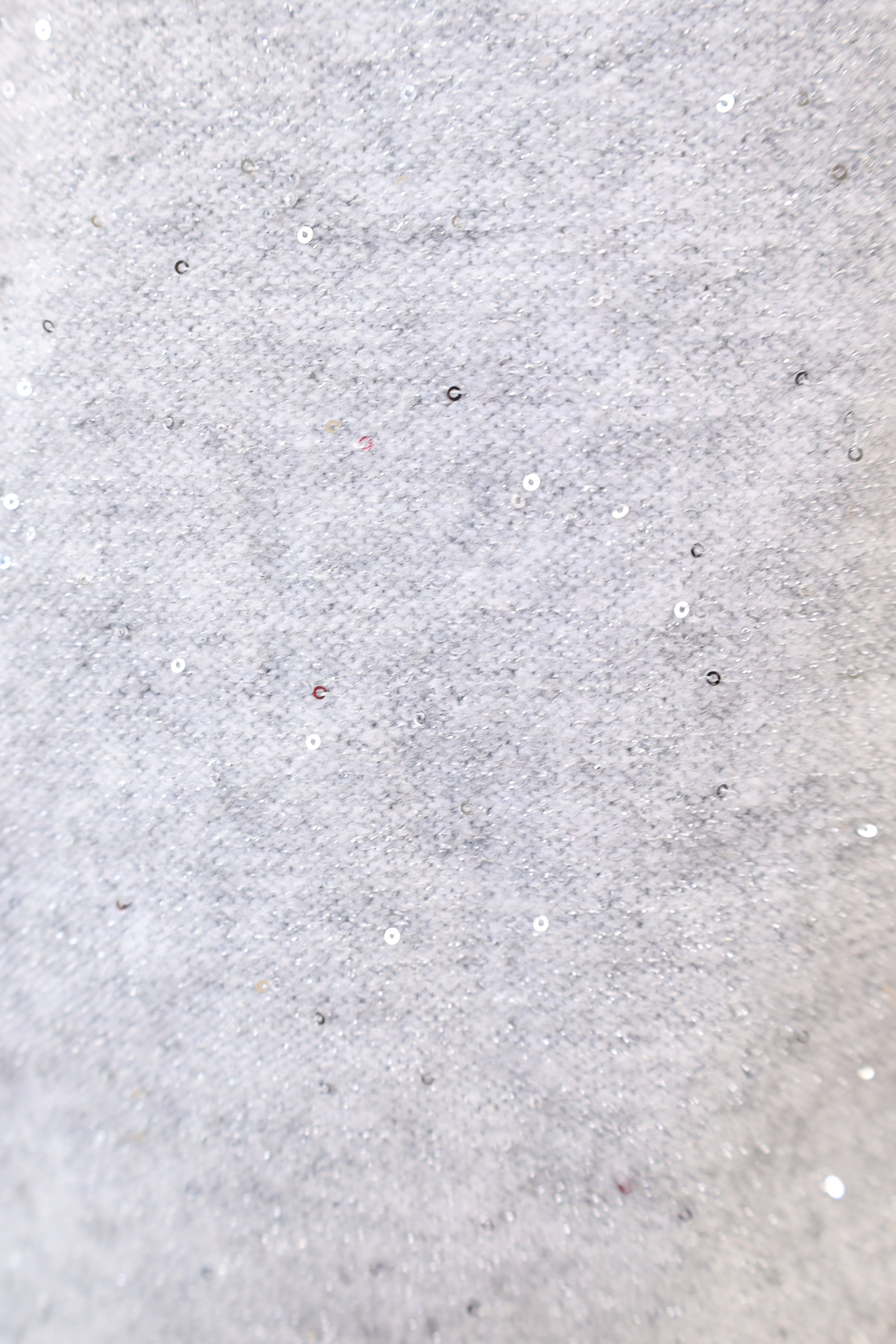 Close-up of Deluc Catalpa Sweater showing silver shimmer detail and soft grey knit texture.