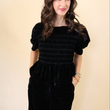 Model wearing Deluc Forrest Top in black velvet with short wide sleeves and soft drape.