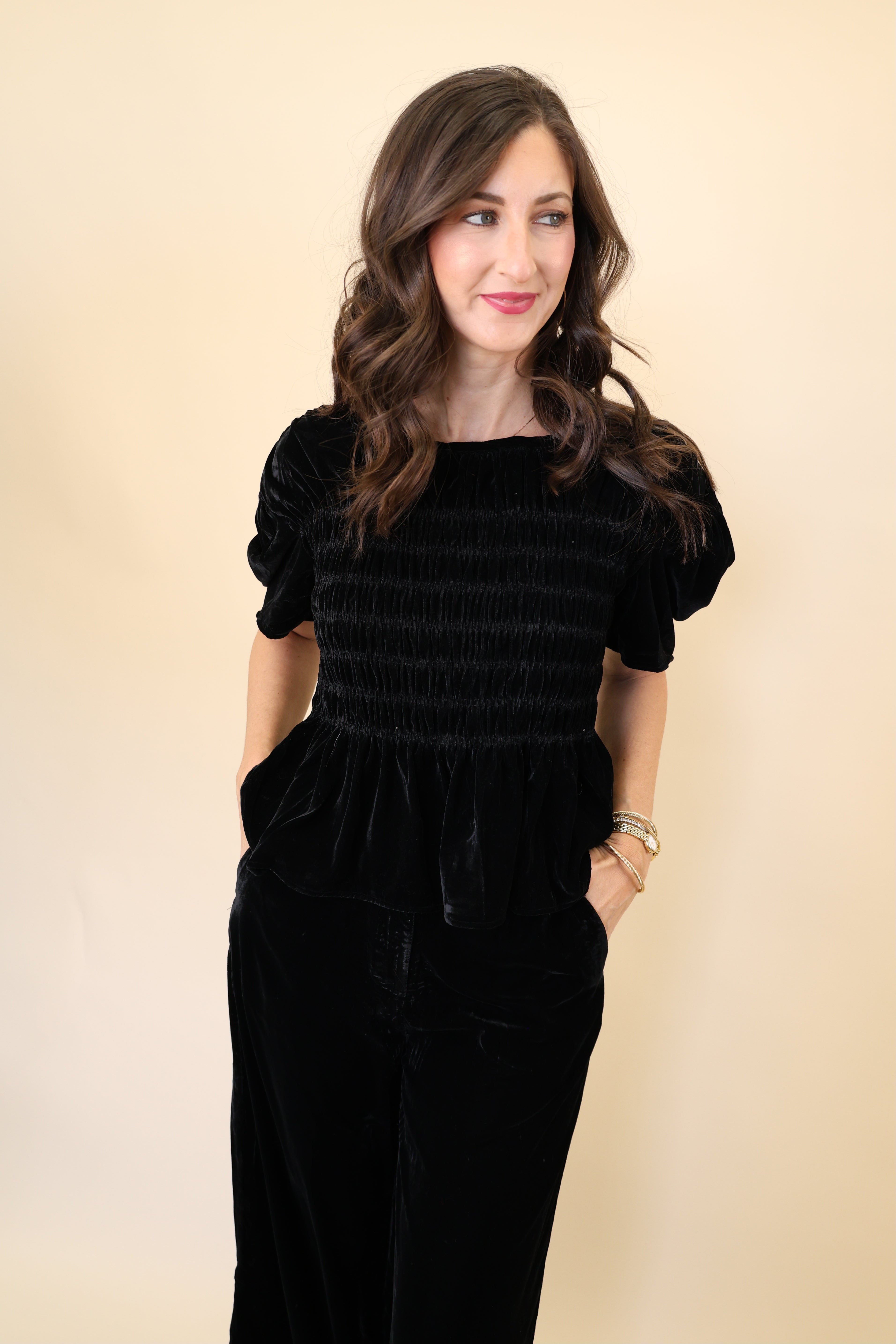 Model wearing Deluc Forrest Top in black velvet with short wide sleeves and soft drape.