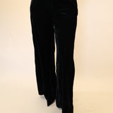 Model wearing Deluc Daisy Pants in black velvet with wide leg silhouette.