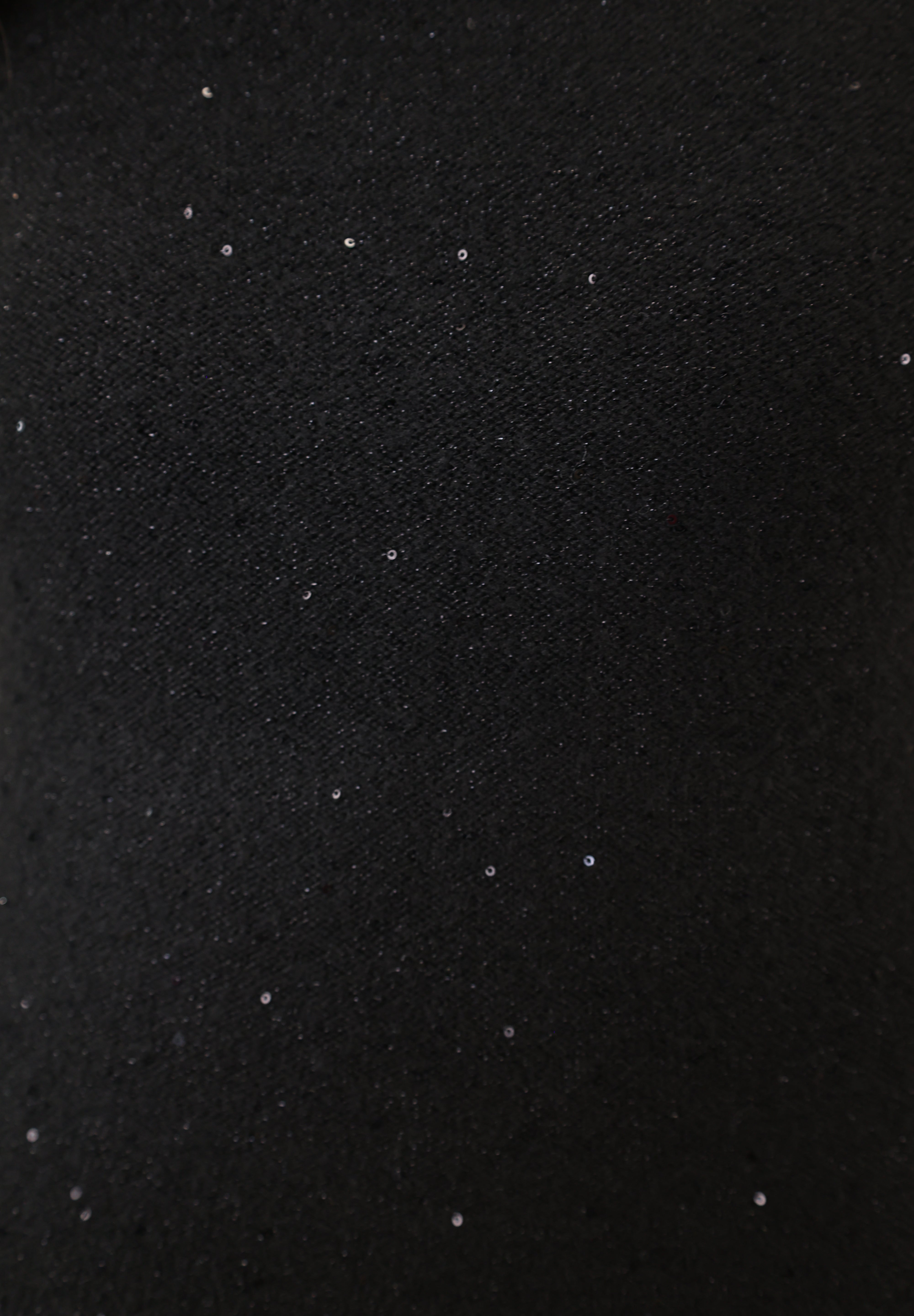 Close-up of Deluc Angel Knit Top showing black textured knit with shimmering accents and sleeveless design.