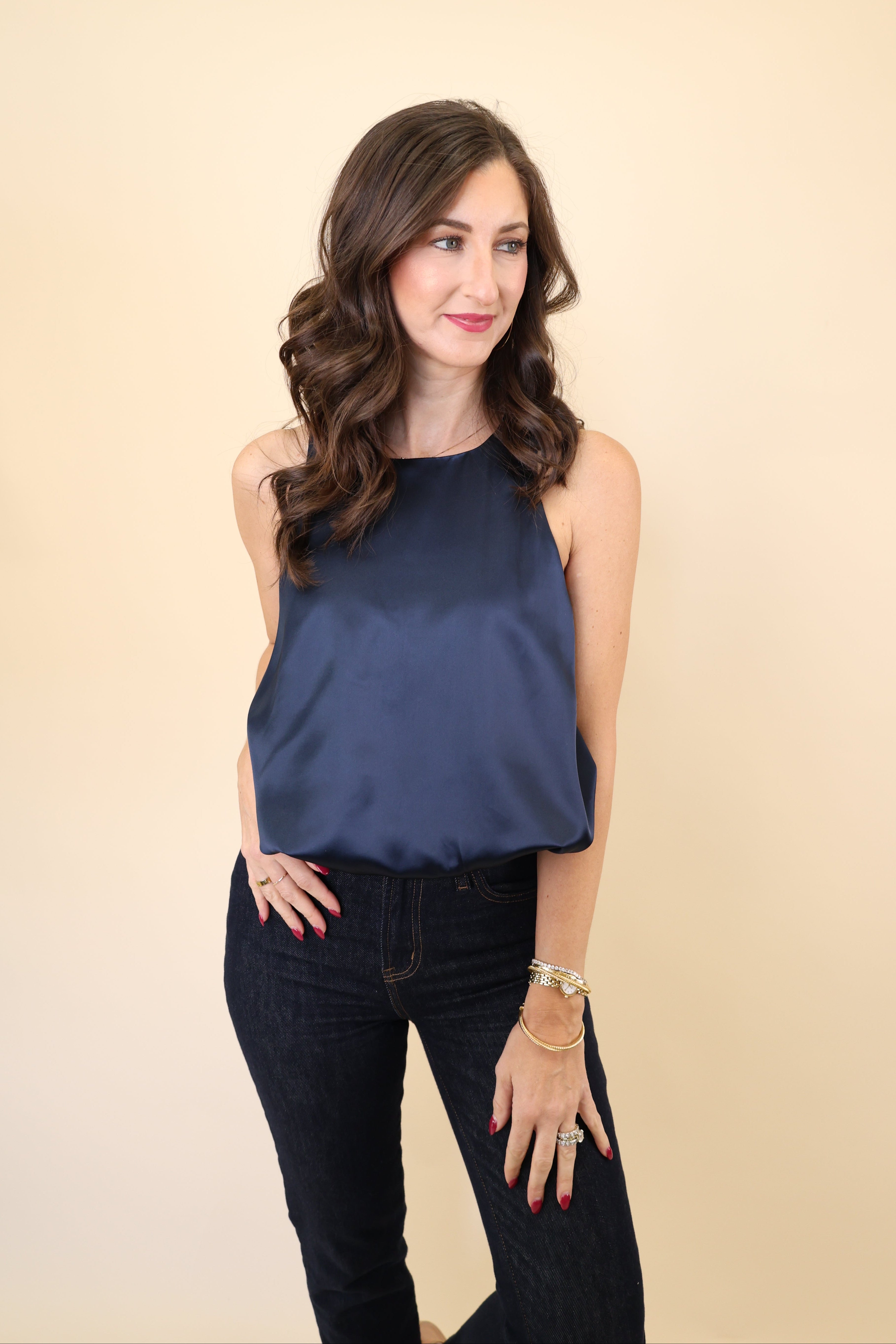 Model wearing Deluc Leonard Top in navy satin with bloused cropped hem and sleeveless tank silhouette.