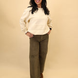 Soft cream sweatshirt with a crewneck design and horizontal stripes created from a contrasting textured knit.