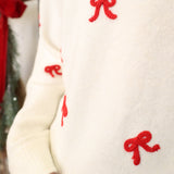 Close-up of Z Supply Tie the Ribbon Sweater highlighting soft knit texture and red bow tie-back design.