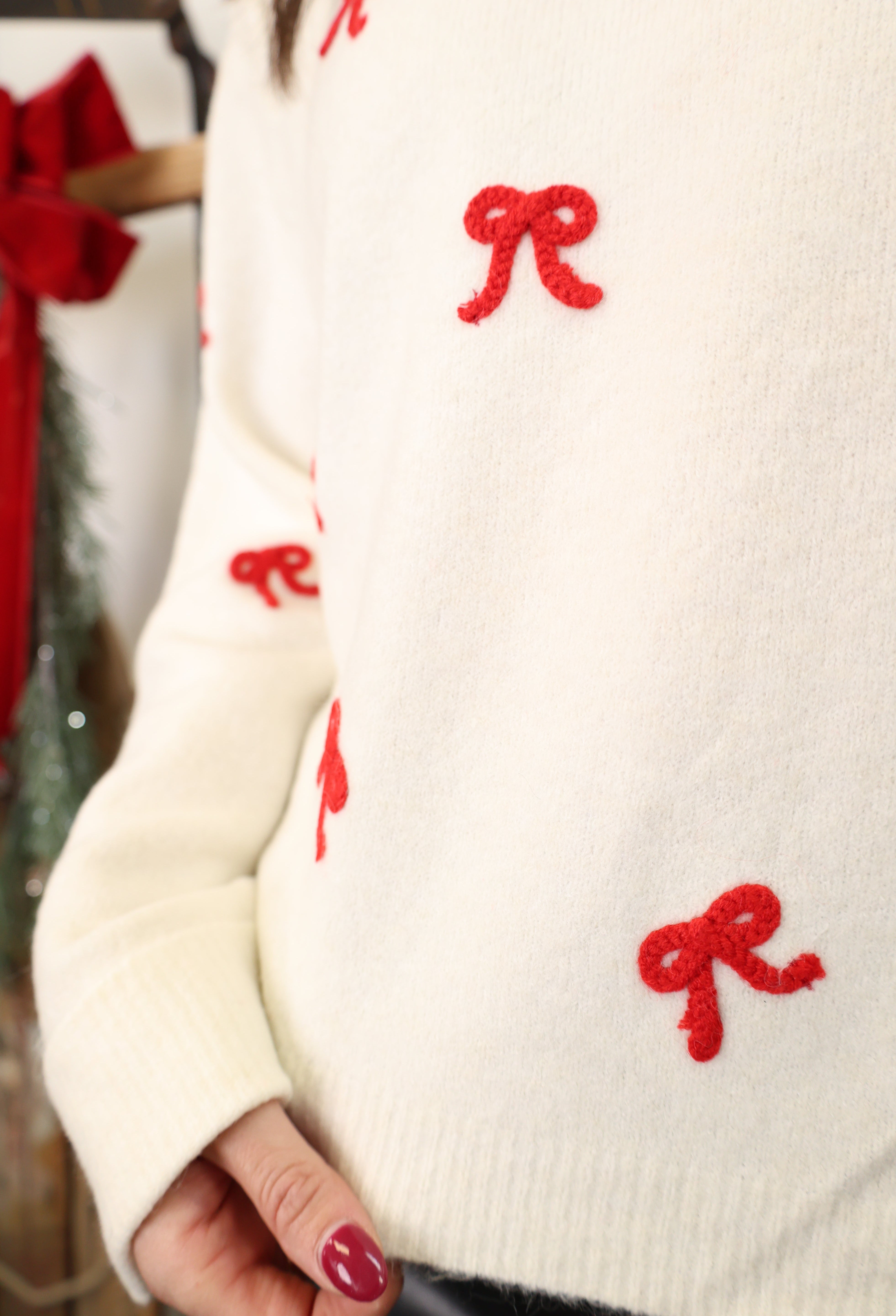 Close-up of Z Supply Tie the Ribbon Sweater highlighting soft knit texture and red bow tie-back design.