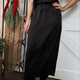 Front view of Another Love black satin maxi skirt with high-rise elastic waistband.