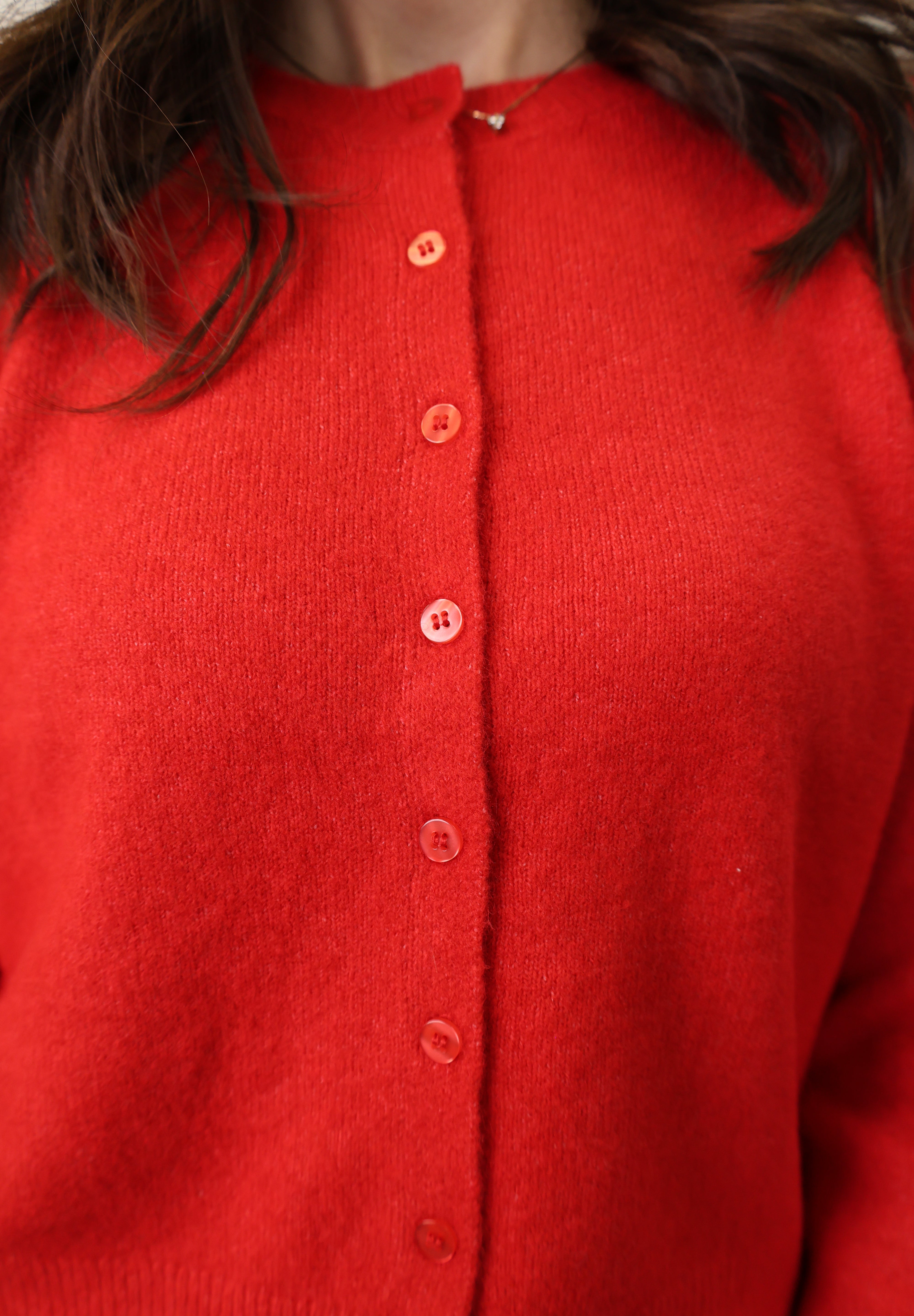 Close-up of Z Supply Medina Sweater showing red knit fabric, crew neckline, and front button details.