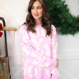 Cozy oversized crewneck sweater by Peach Love in pink and white with festive JOY front print.