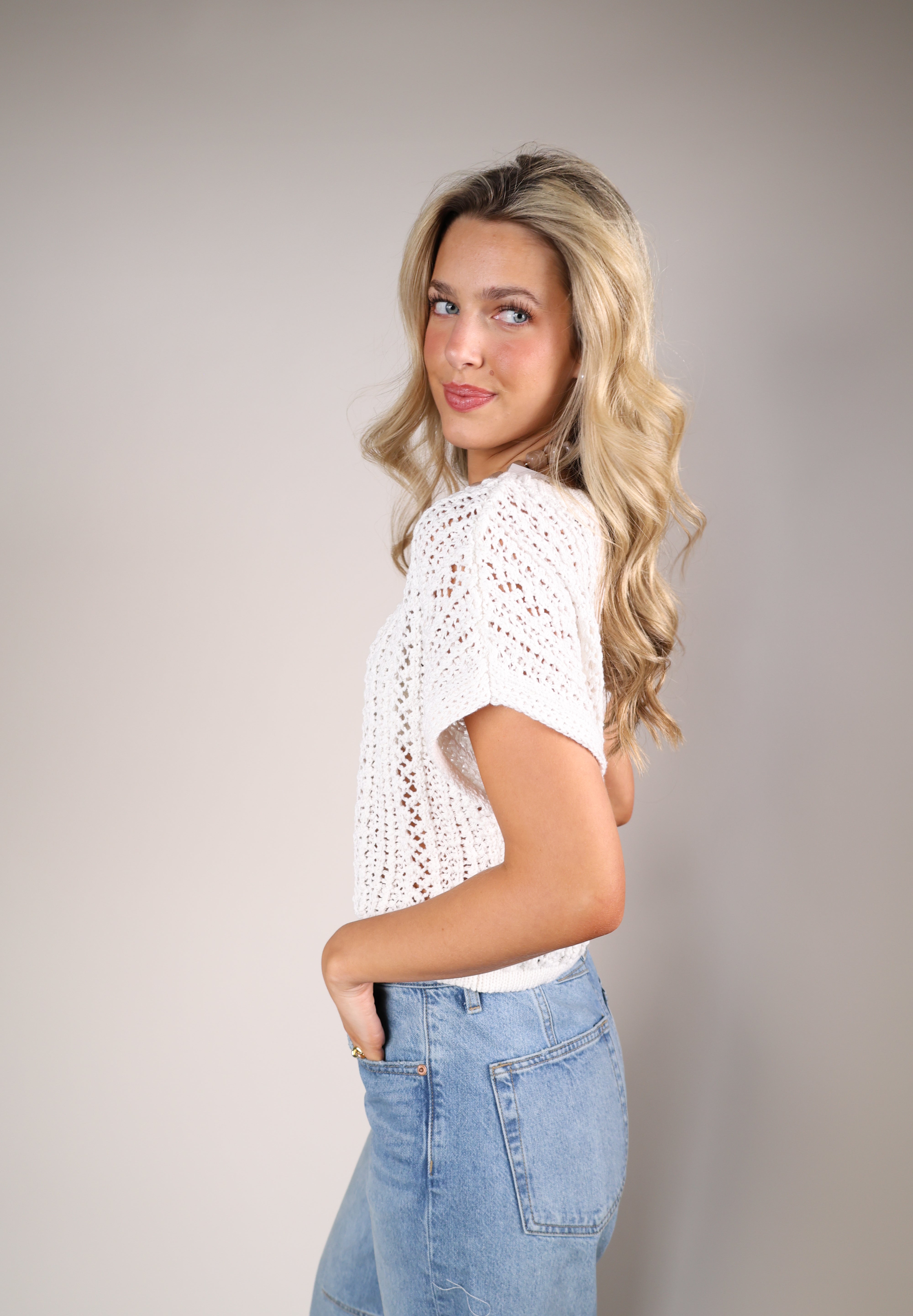 Ivory Z Supply Ballast Crochet Top with airy open weave knit and cap sleeves, paired with neutral wide-leg jeans for a polished casual look.