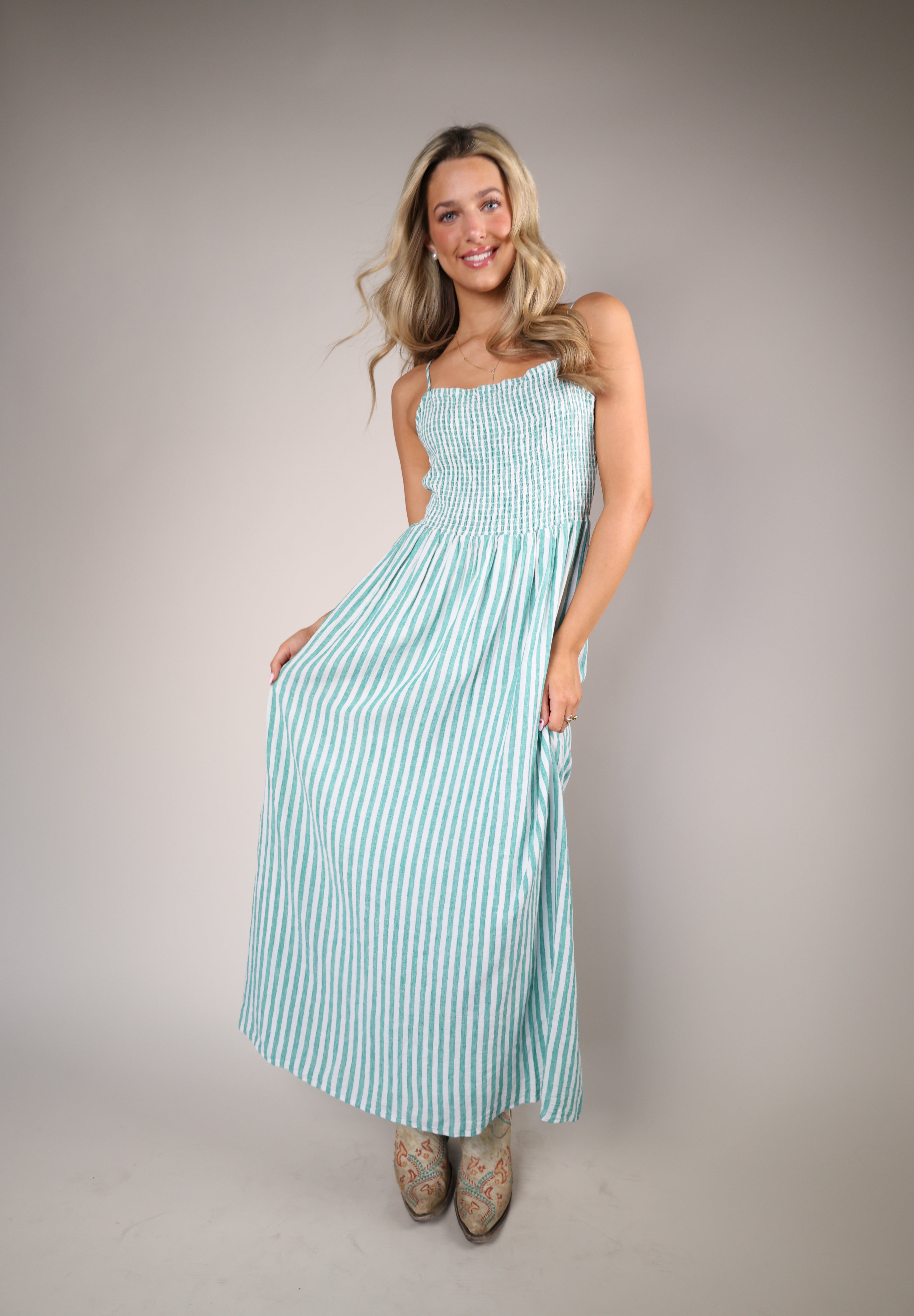 Green and white striped Z Supply Bayside midi dress with fitted smocked top and flowy skirt, styled seaside.