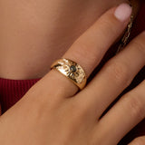 Gold vintage burst ring with green center stone and pavé crystal accents.