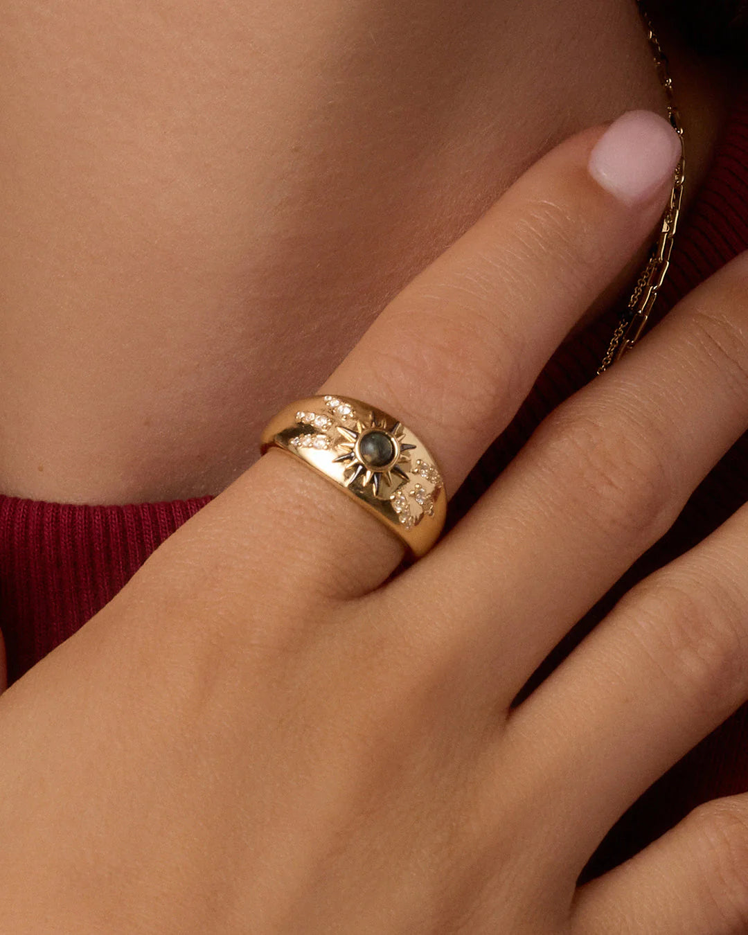 Gold vintage burst ring with green center stone and pavé crystal accents.