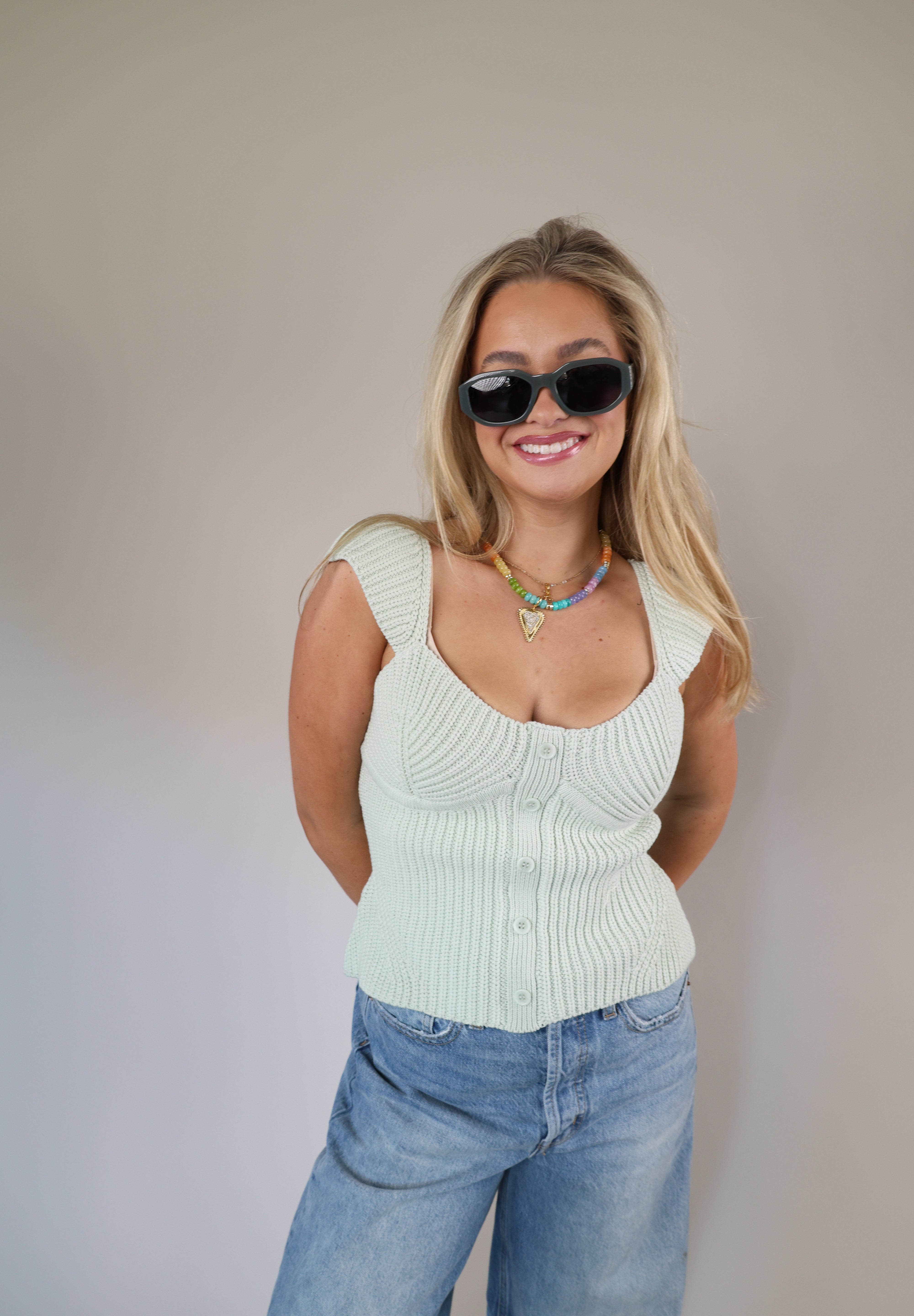 Pastel mint ribbed sweater top with wide straps, front buttons, and a slightly cropped, fitted style.