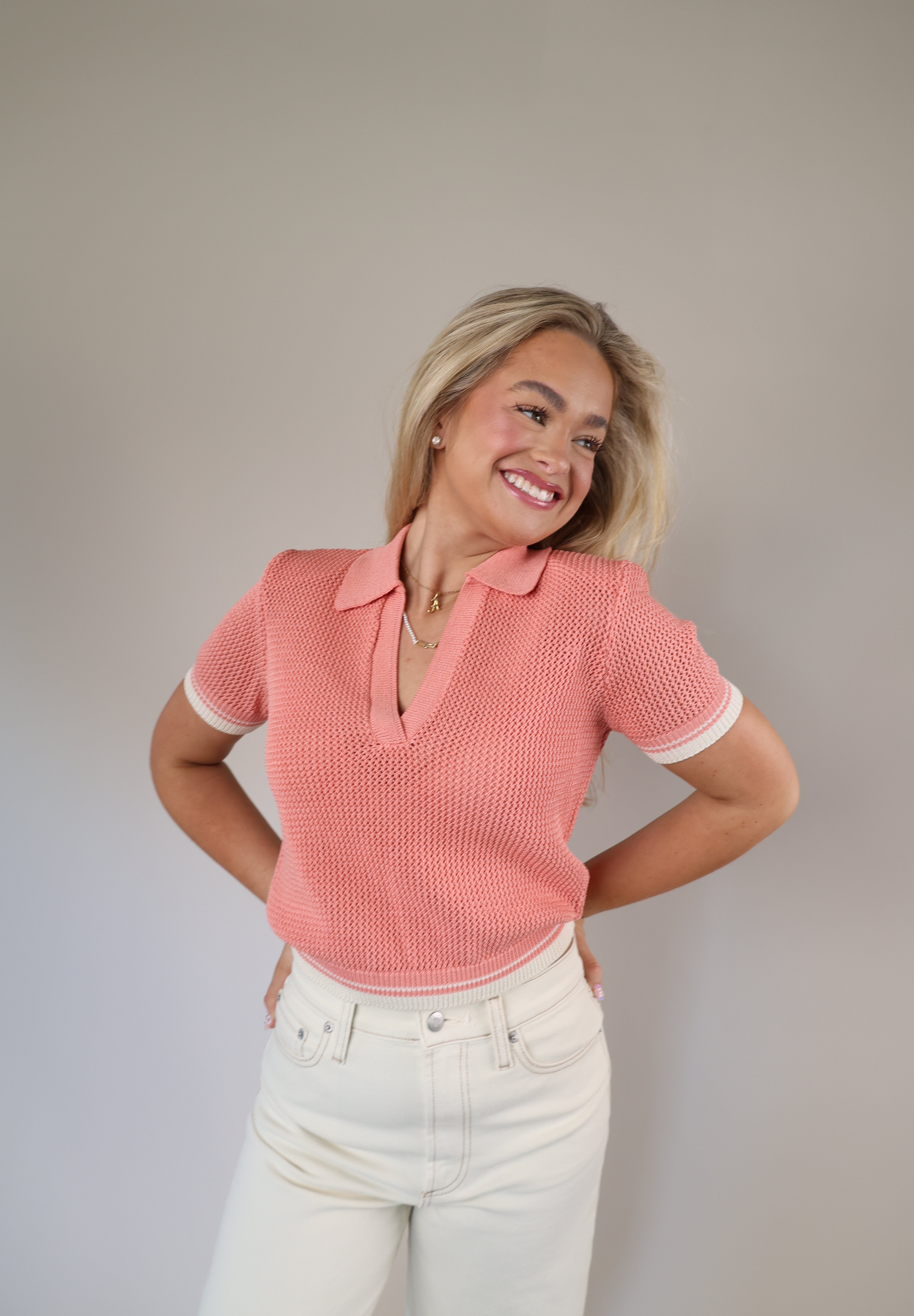 Cropped pink sweater top featuring short sleeves and a Johnny collar design for a modern, casual look.