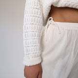 White linen wide-leg pants featuring side pockets and a comfortable elastic drawstring waistband.