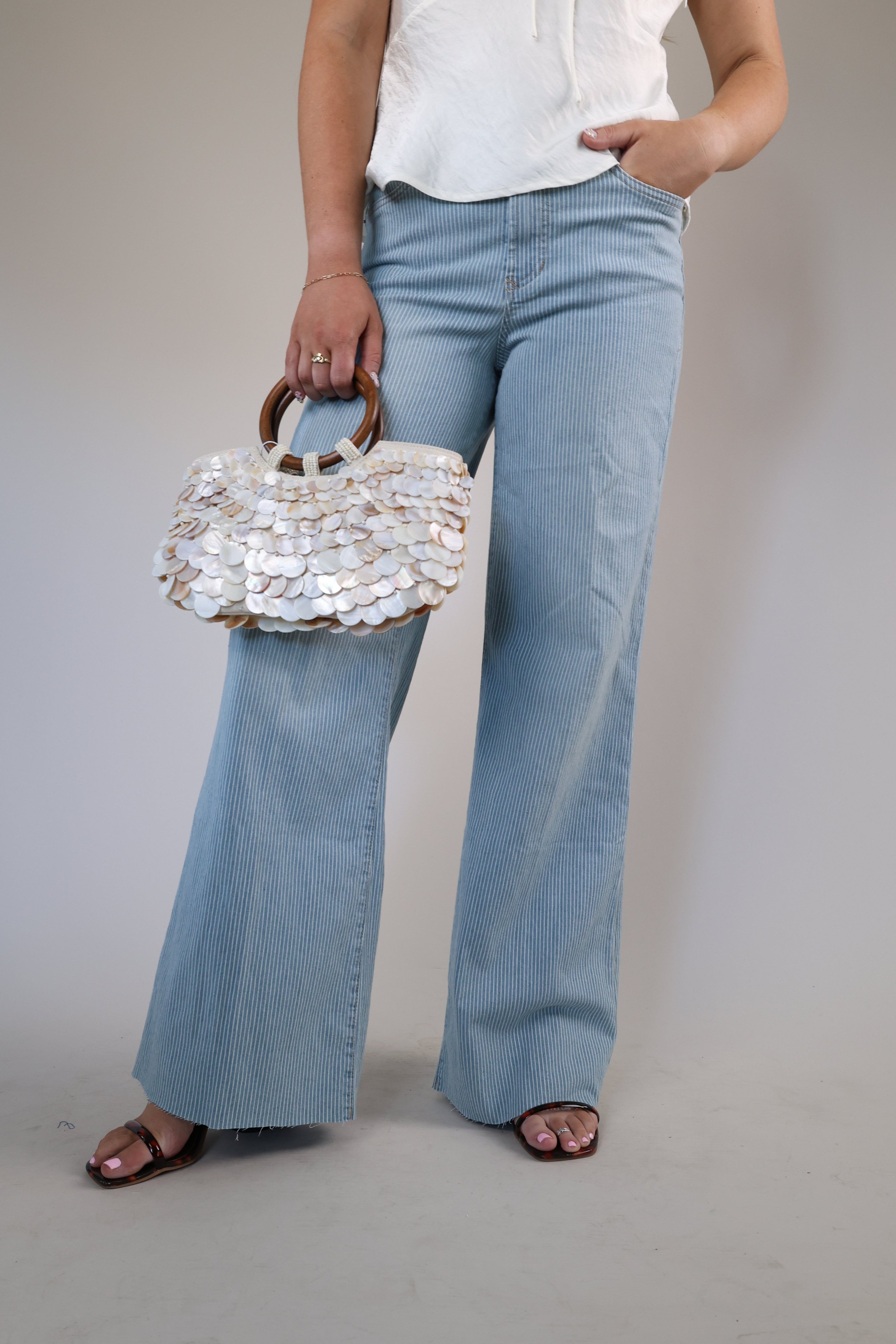 Wide-leg denim jeans with a high-rise fit and raw edge hem detailing.