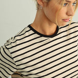 Woman wearing a black and white striped shirt against a plain background