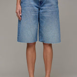 Person wearing blue denim shorts on a plain background