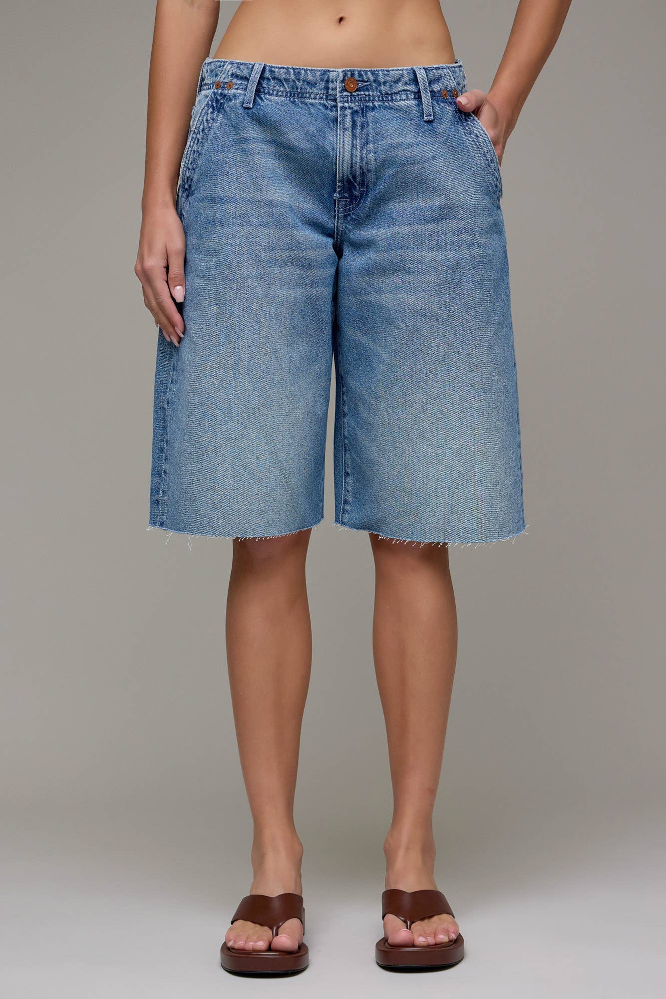 Person wearing blue denim shorts on a plain background