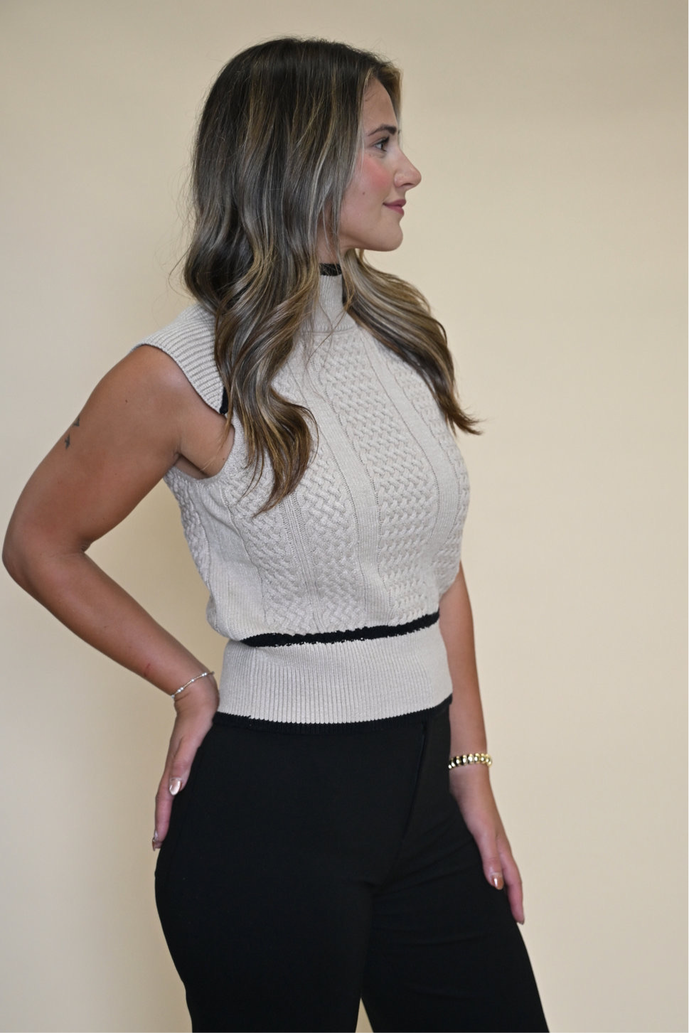 Dèluc Sleeveless Turtleneck Sweater Vest featuring detailed stitching above the waist, around the neckline, and diagonally from collar to armhole for a refined finish.