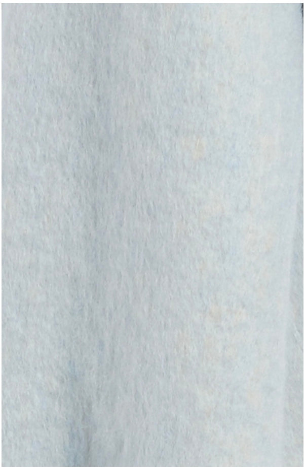 Close-up of Free People blue blanket scarf highlighting soft fabric and white fringe trim.