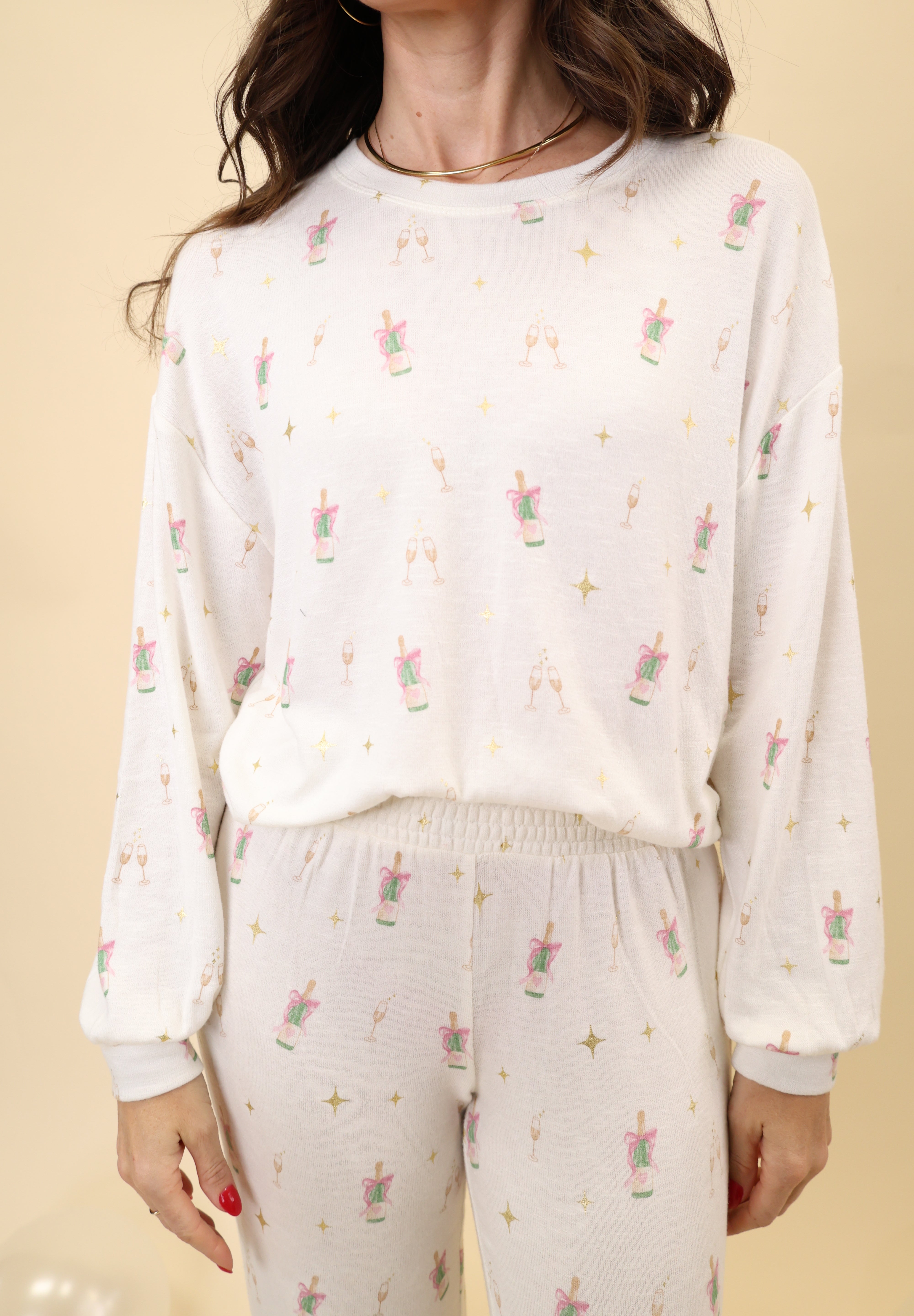 Soft long-sleeve crewneck top featuring an allover champagne toast print and an easy, relaxed silhouette.
