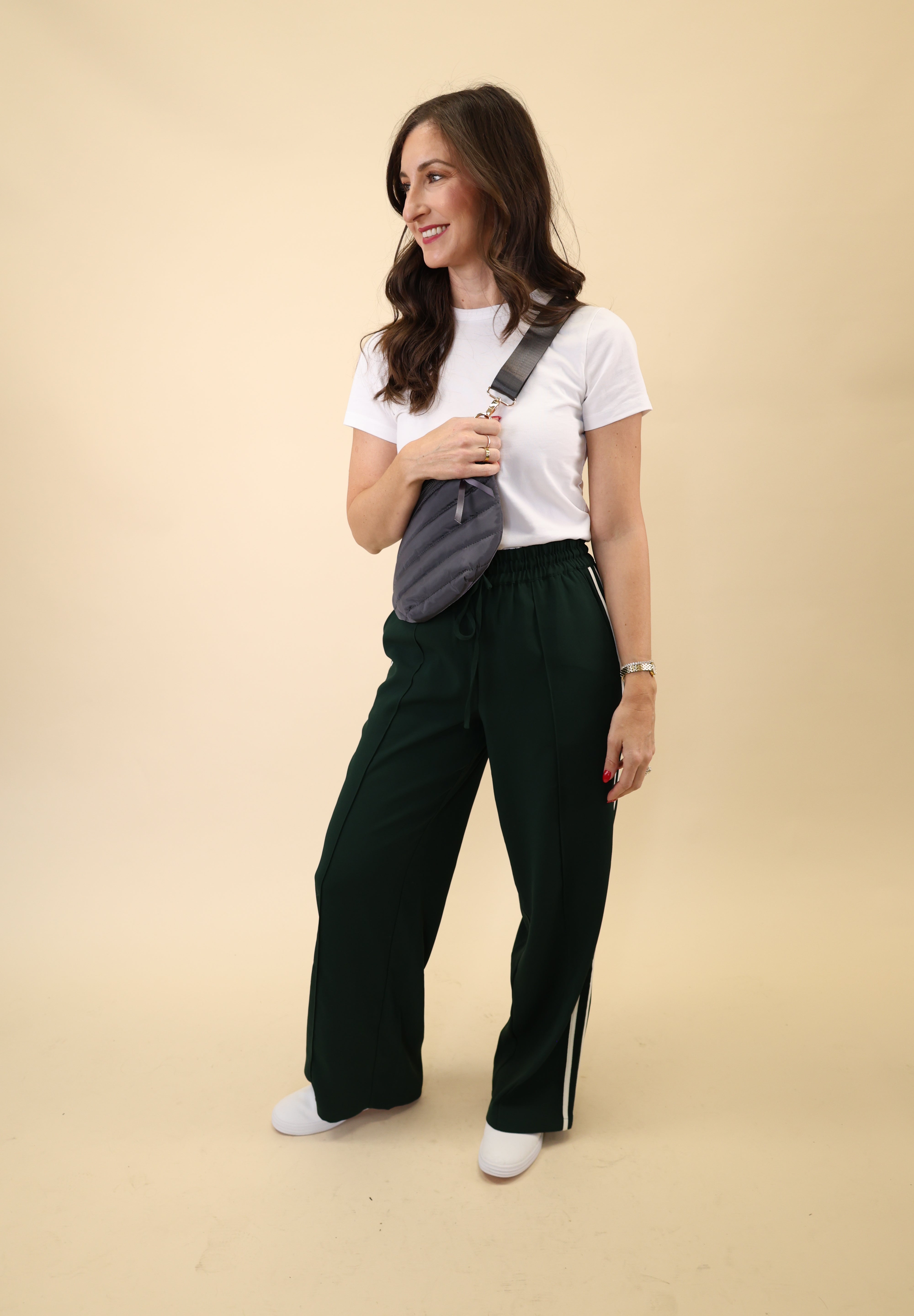 Wide-leg green Z Supply Saunder Track Pant with a lightweight feel, high waist, and crisp white stripes running down the seams.