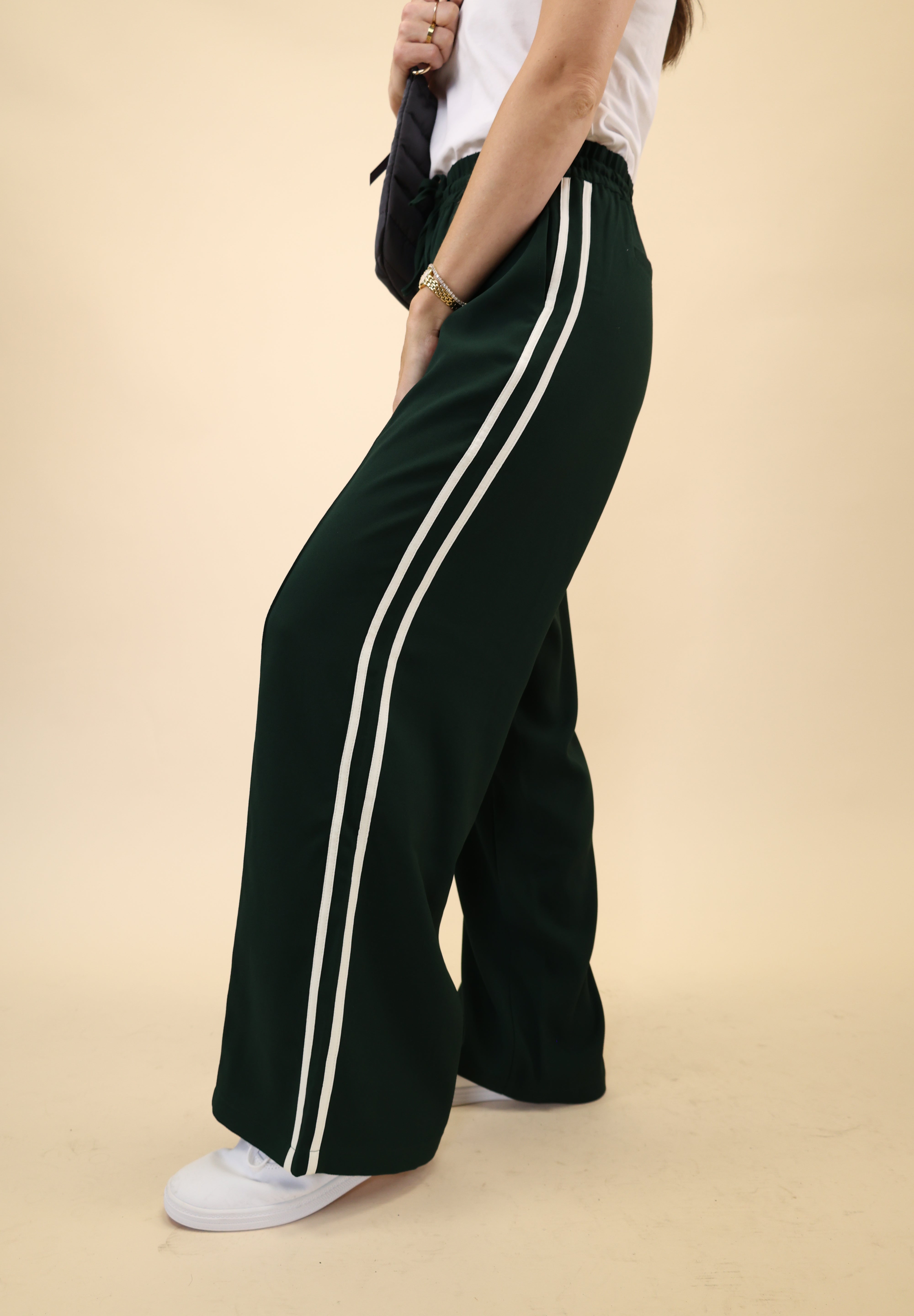 Light green Z Supply Saunder Track Pant with a flowy wide-leg fit, high-rise waist, and white stripe detailing along the seams.