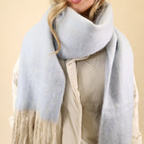 Free People Winter Chill blanket scarf in a super soft knit, featuring a cozy oversized design in blue with cream fringe trim.