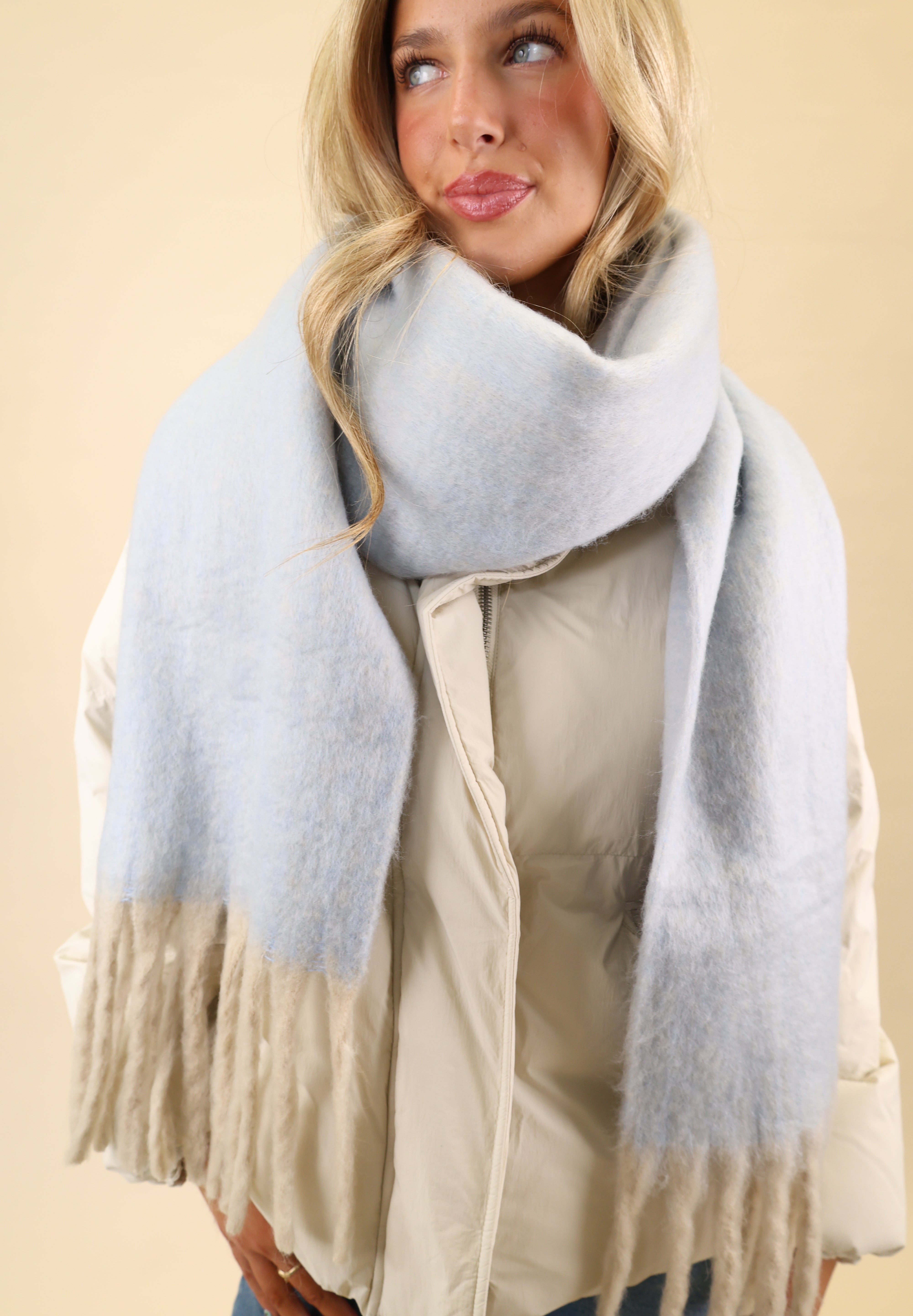 Free People Winter Chill blanket scarf in a super soft knit, featuring a cozy oversized design in blue with cream fringe trim.