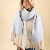 Free People Winter Chill scarf with a cute blanket-style silhouette, crafted from ultra-soft knit in blue with cream fringe trim.