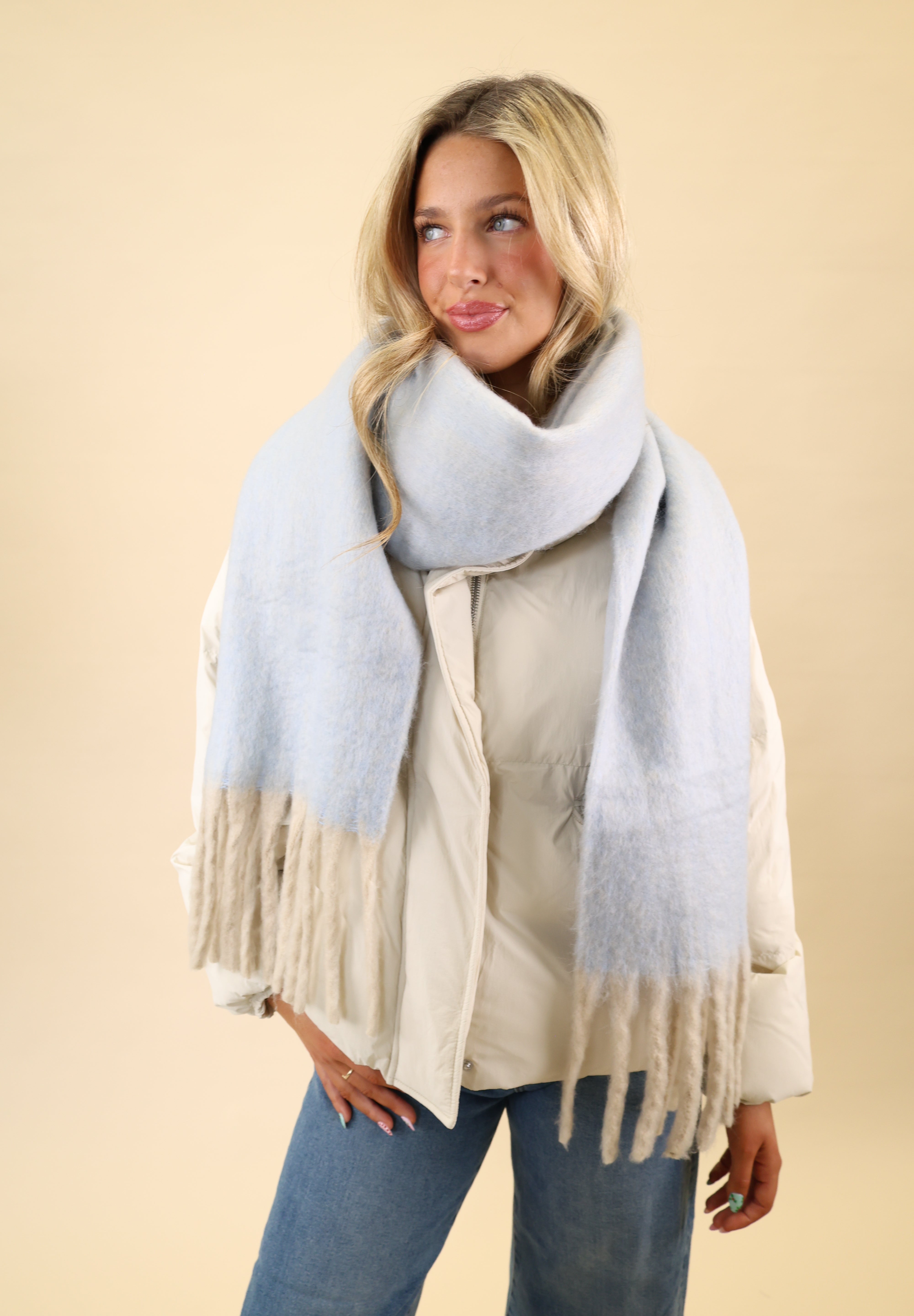 Free People Winter Chill scarf with a cute blanket-style silhouette, crafted from ultra-soft knit in blue with cream fringe trim.