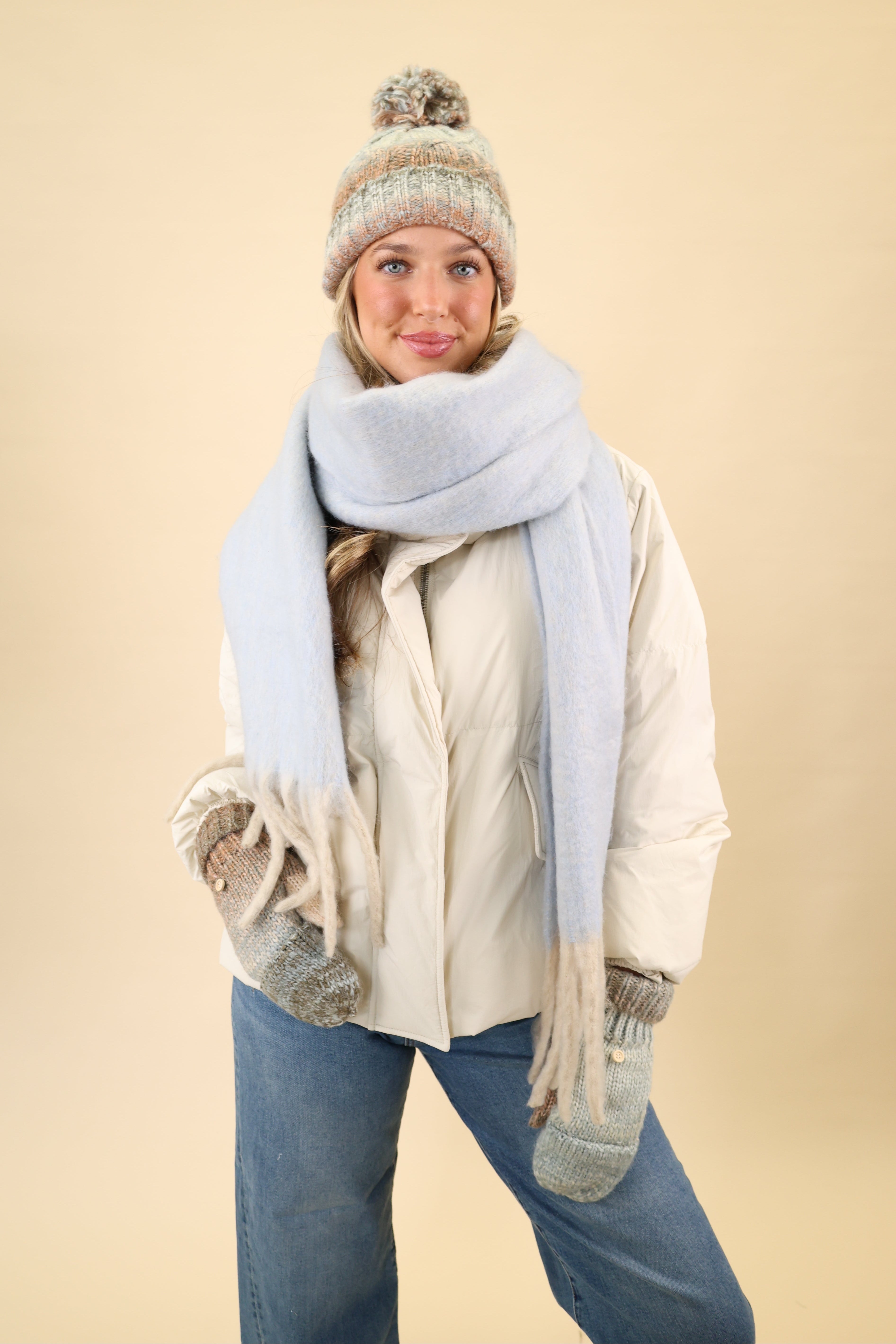 Super soft knit Free People Winter Chill blanket scarf in blue, designed for cozy layering with cream fringe edges.