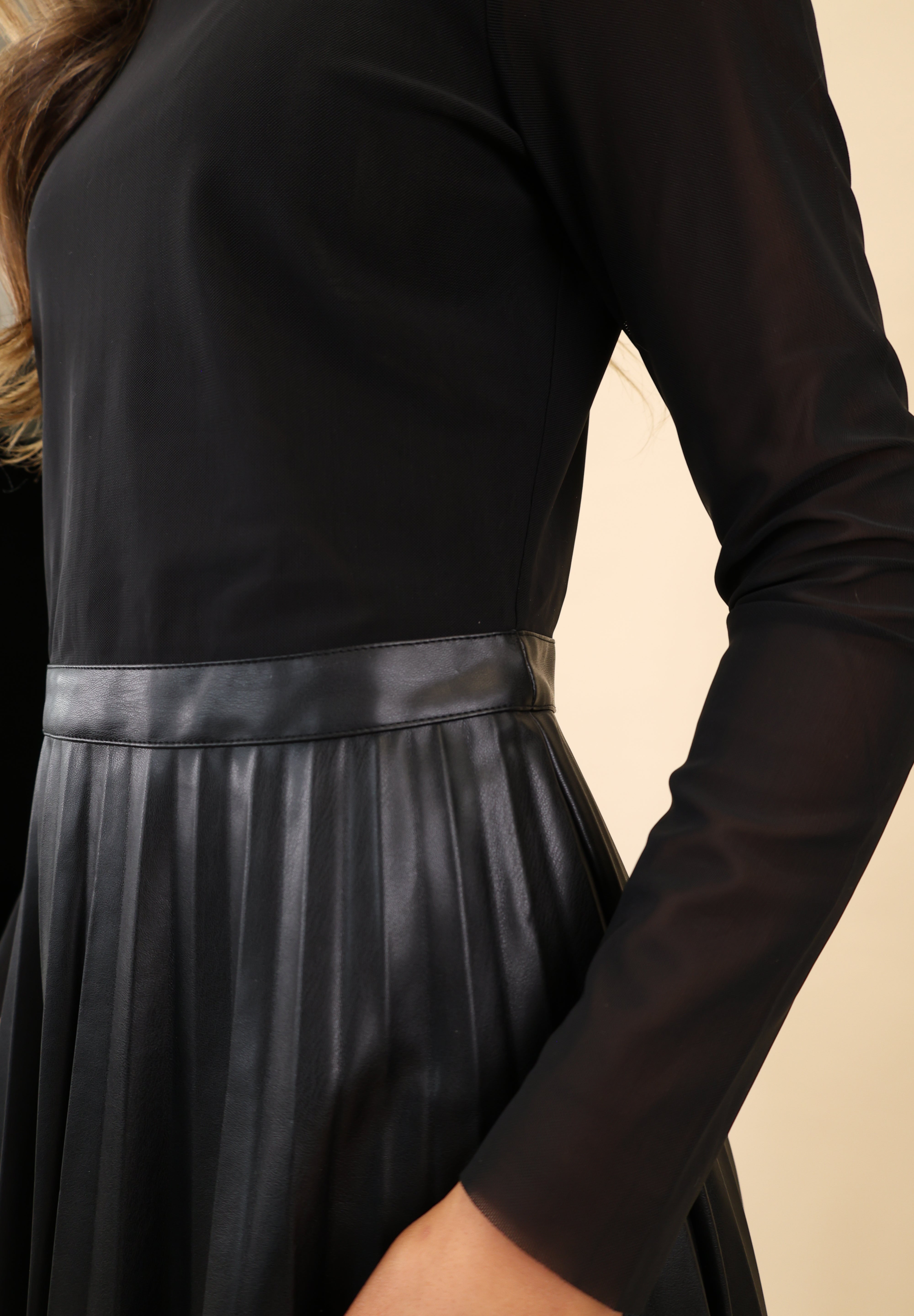 Steve Madden Nevah faux-leather mini dress featuring pleated detailing, a mock neckline, and long sleeves.