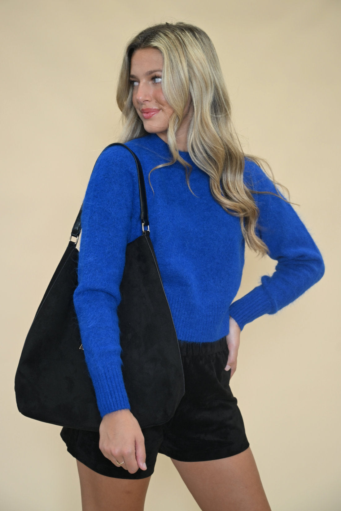 Pistola Sara Crewneck Sweater in Azure Blue styled with black handbag & black suede shorts — soft knit women’s sweater from Shear Boutique