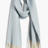 Cozy blue blanket scarf by Free People featuring long white fringe at the edges.