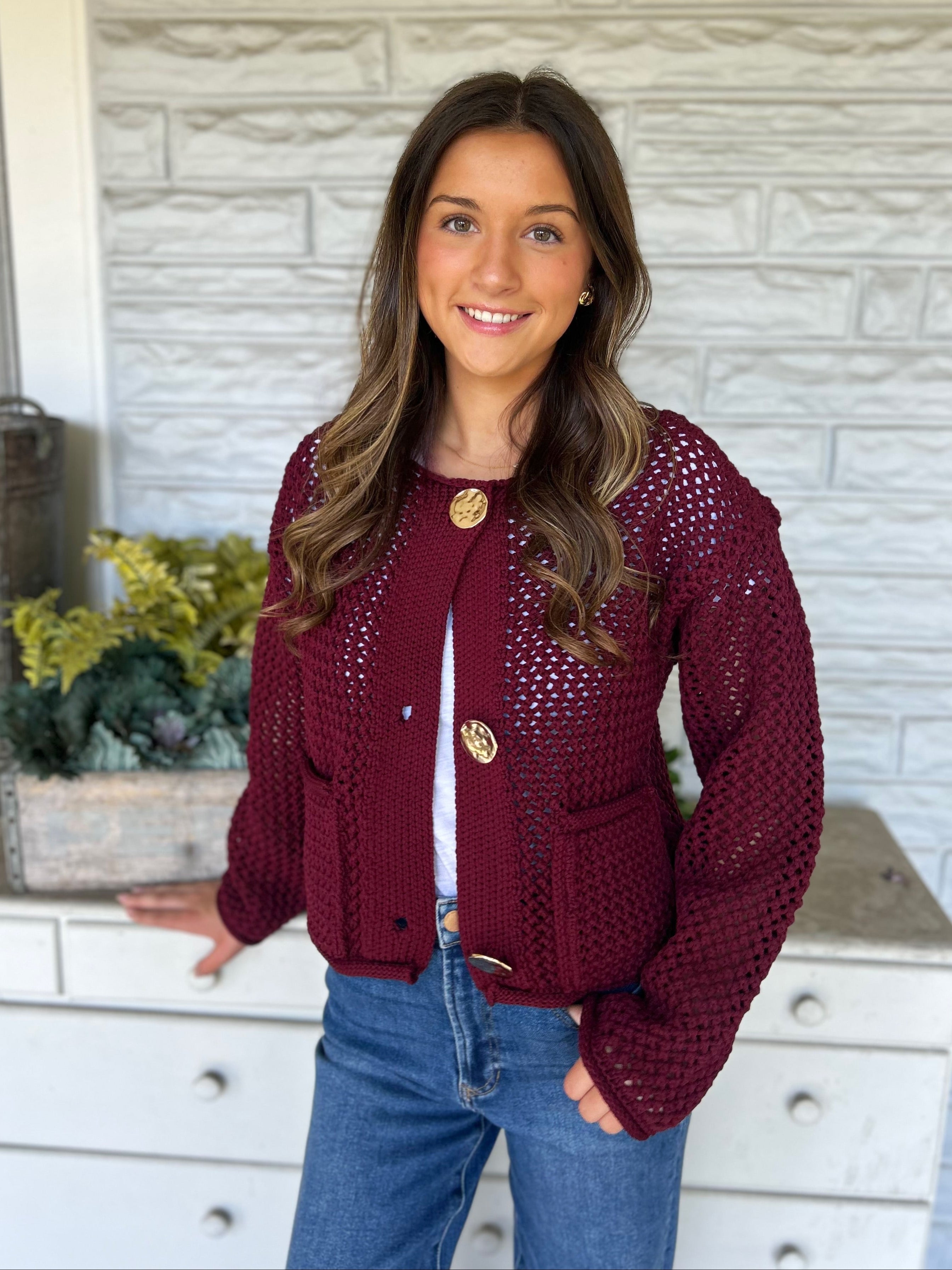 Bold red Dear John Sweater with chunky knit texture and three gleaming gold buttons — warm, stylish, and eye-catching.