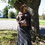 Women’s classic plaid skirt styled for fall with a fitted sweater and boots at Shear Boutique Olney