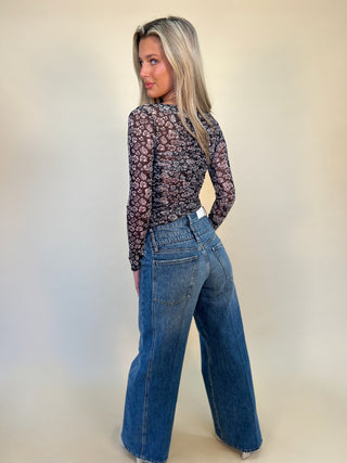back full length view of caleb high rise relaxed stacked waist jeans and back of mesh print top- shear boutique fall collection 