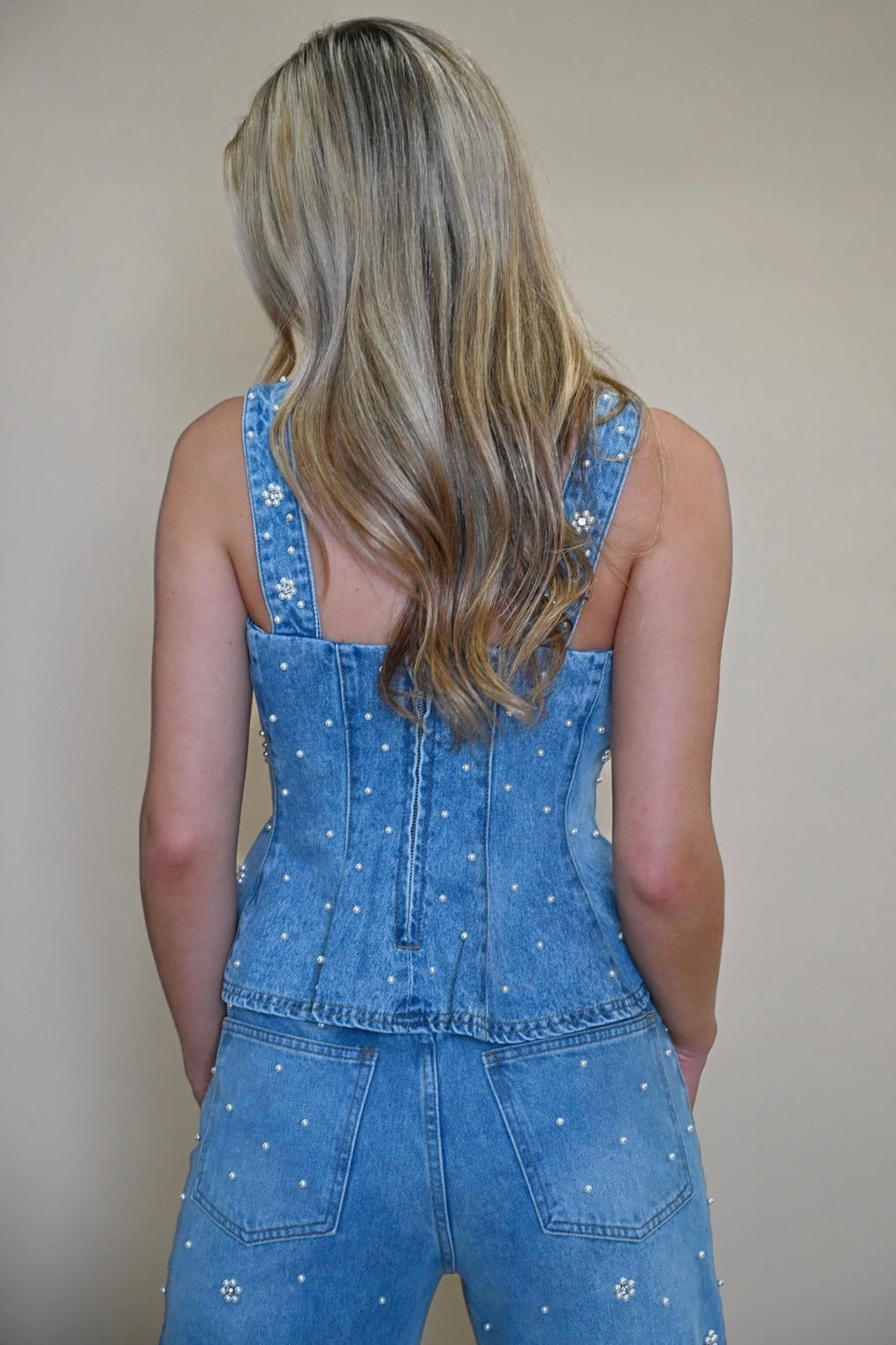 back view of Fiorella top showing zipper and pearl embellishment details. Women's peplum denim corset top from Shear Boutique, Maryland 