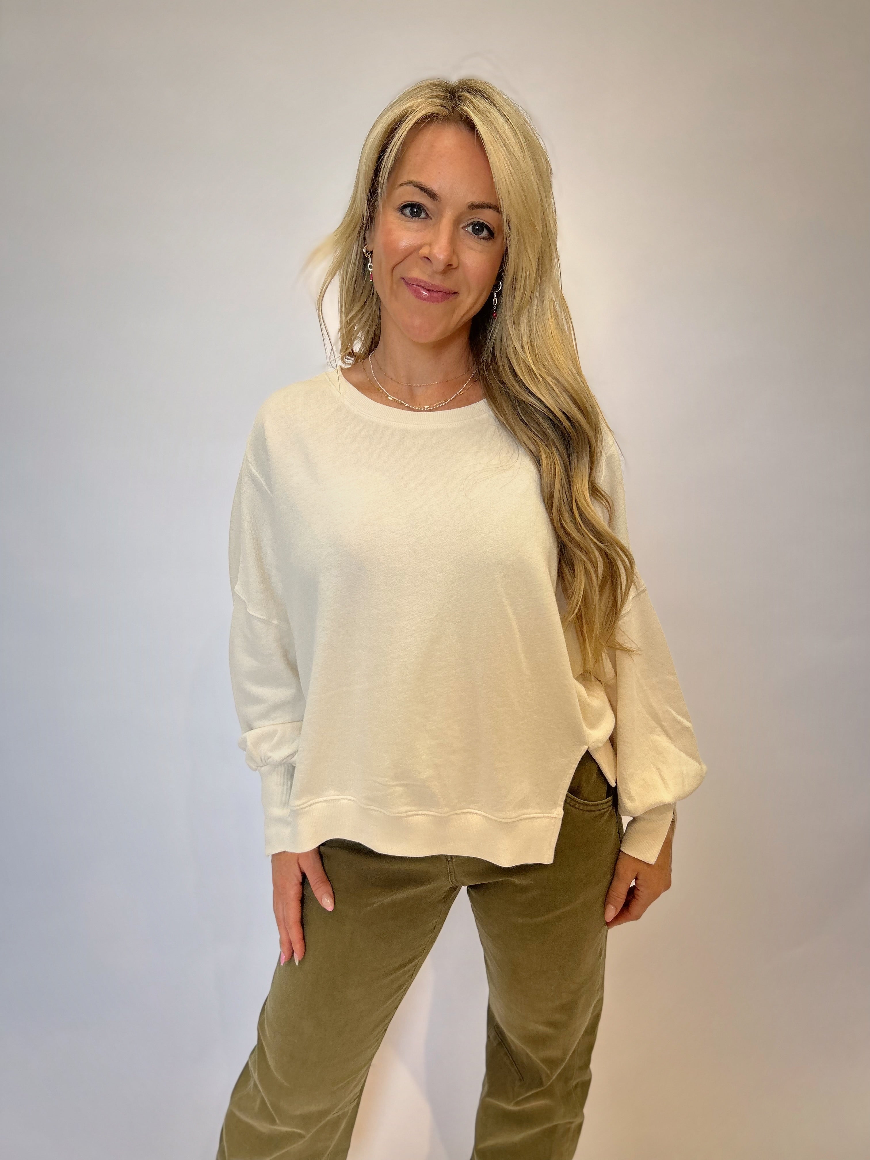 Dear John Trenton Long Sleeve Shirt — soft white fabric with a classic round neckline, puff sleeves, and side slits for a cozy yet elevated look.