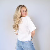 Feminine linen blouse with tie-front bows styled with wide leg denim and gold chain belt