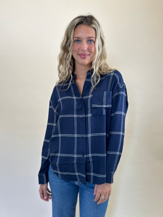 Soft-washed Z Supply River Plaid Button-Up in blue and white, featuring a collared neckline, button-front closure, long sleeves, and a single chest pocket.