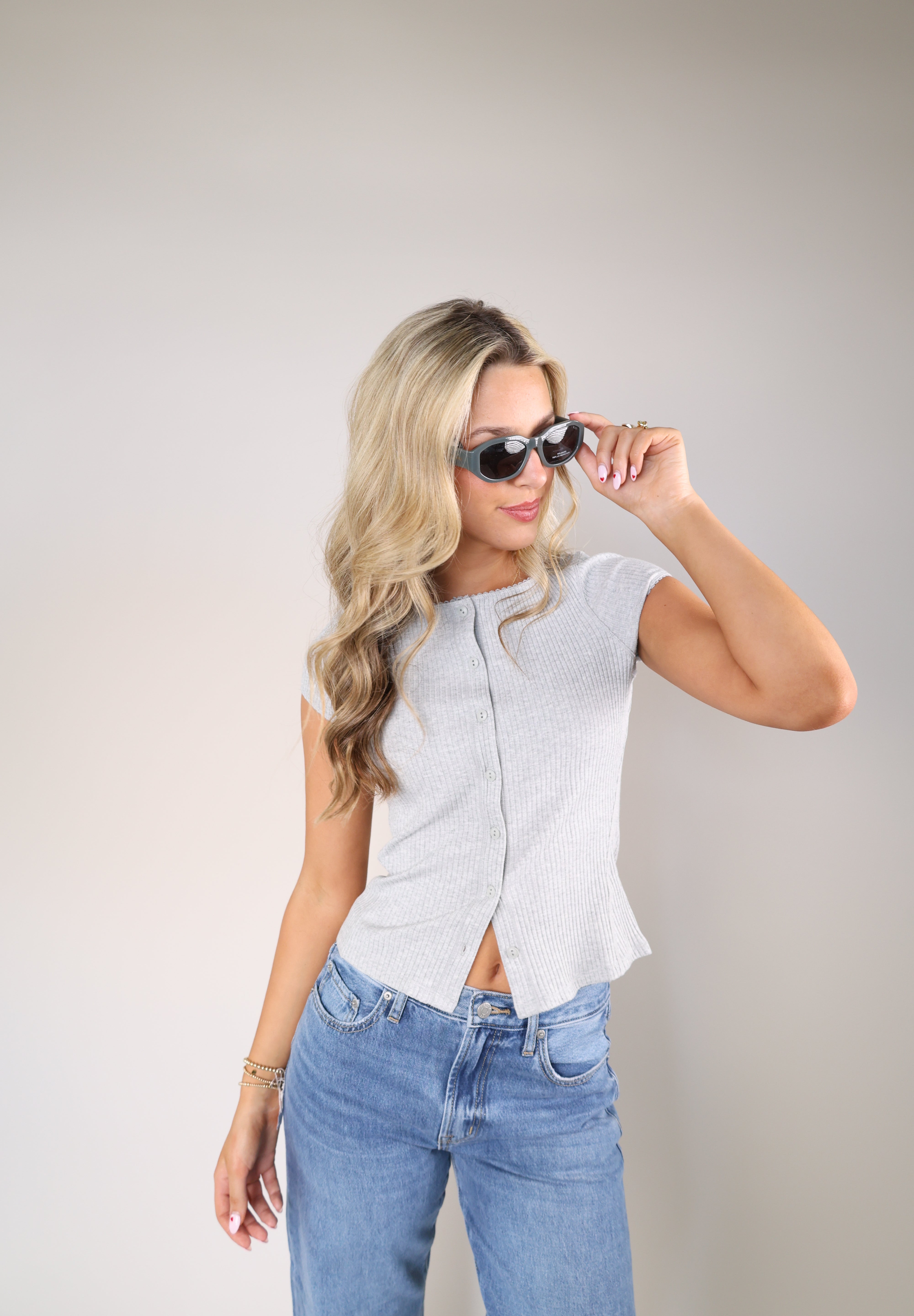 Women’s Free People ribbed button-front cardigan in grey styled with relaxed denim.