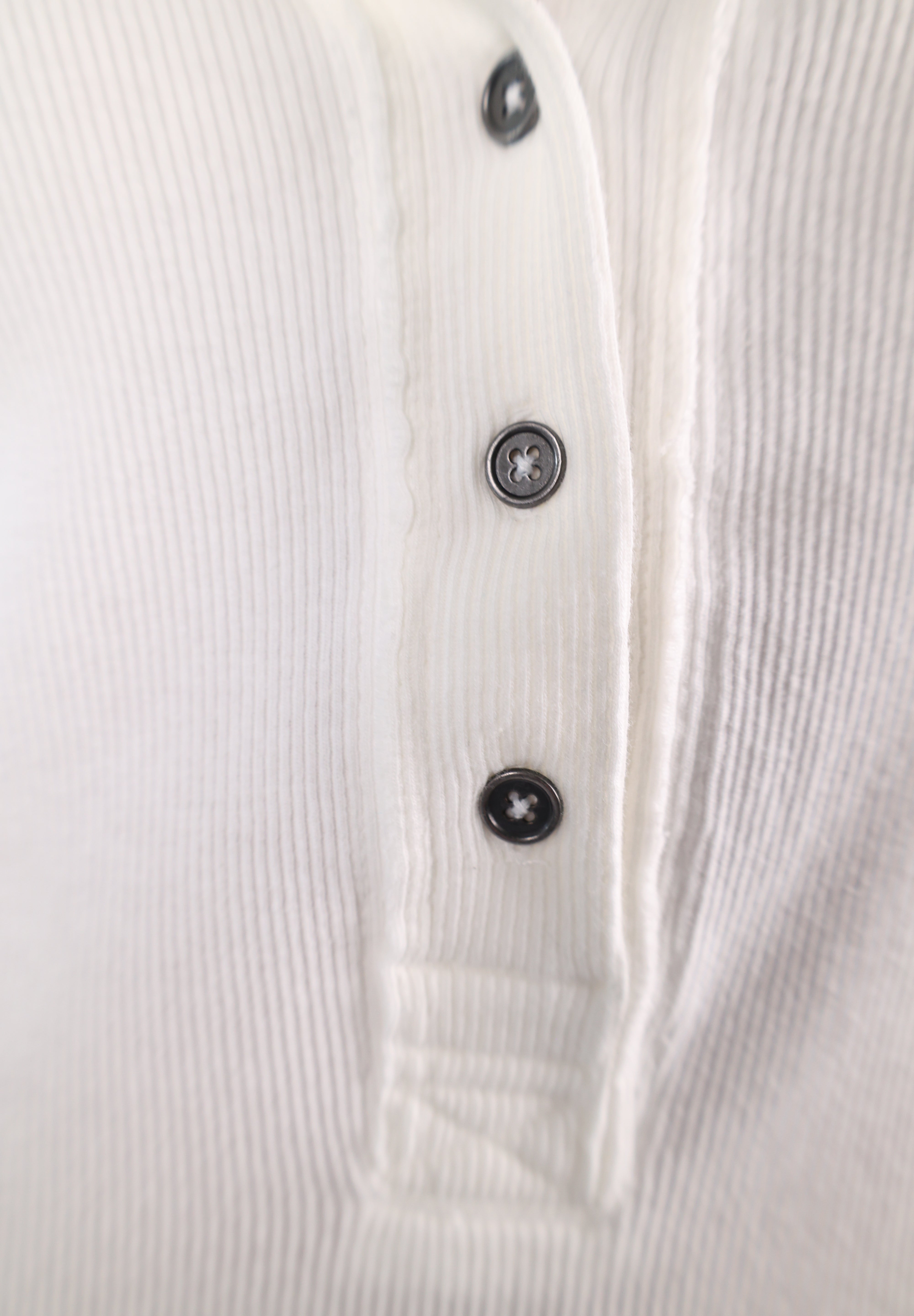 Close-up of Free People Jamie Henley featuring textured ribbed fabric and contrast button detailing.