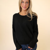 Black crewneck sweater by Dear John with relaxed drop shoulders and ribbed sleeve detailing.