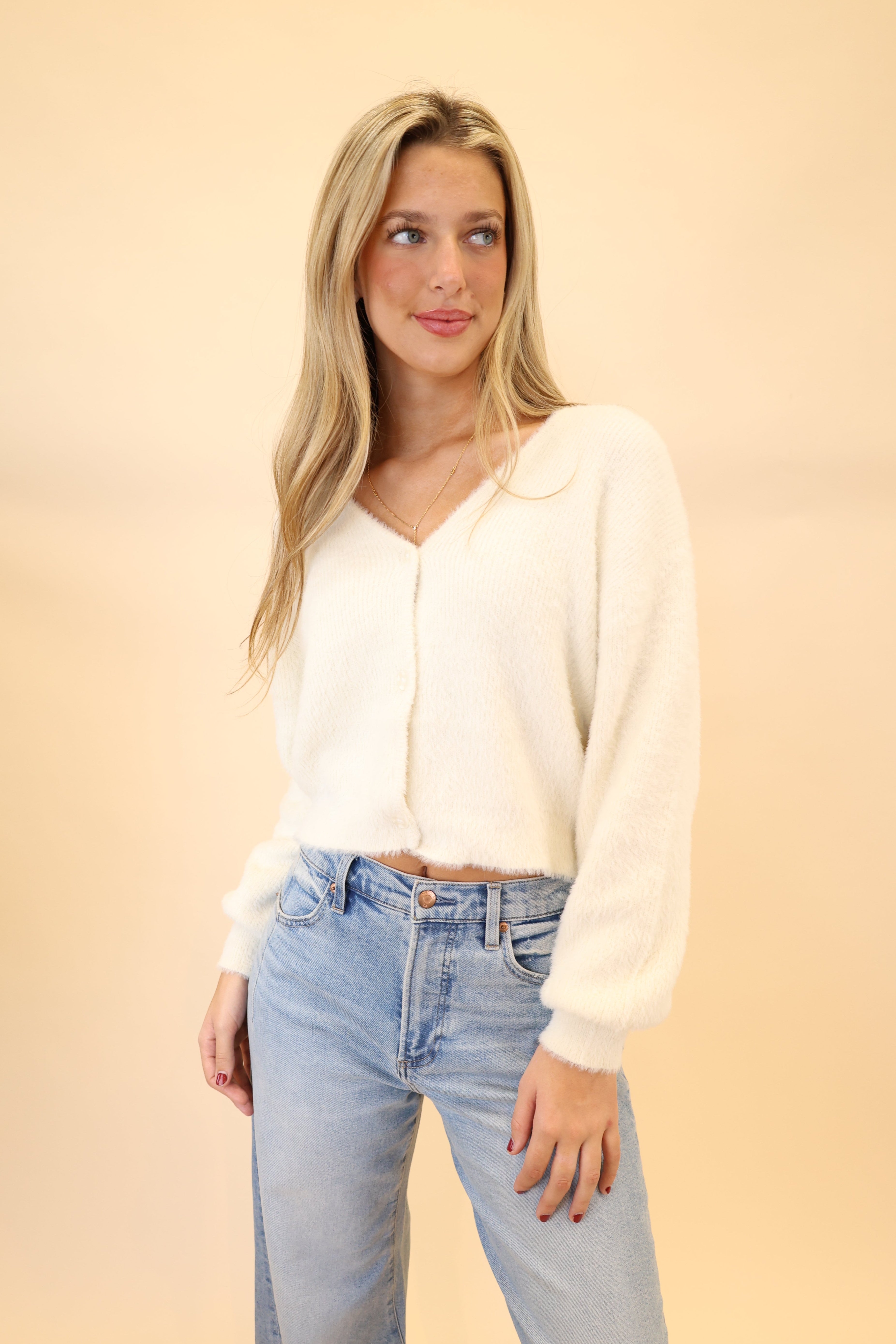 Model wearing white Z Supply Sadira fluffy cardigan with V-neckline, long sleeves, and button-front closure.